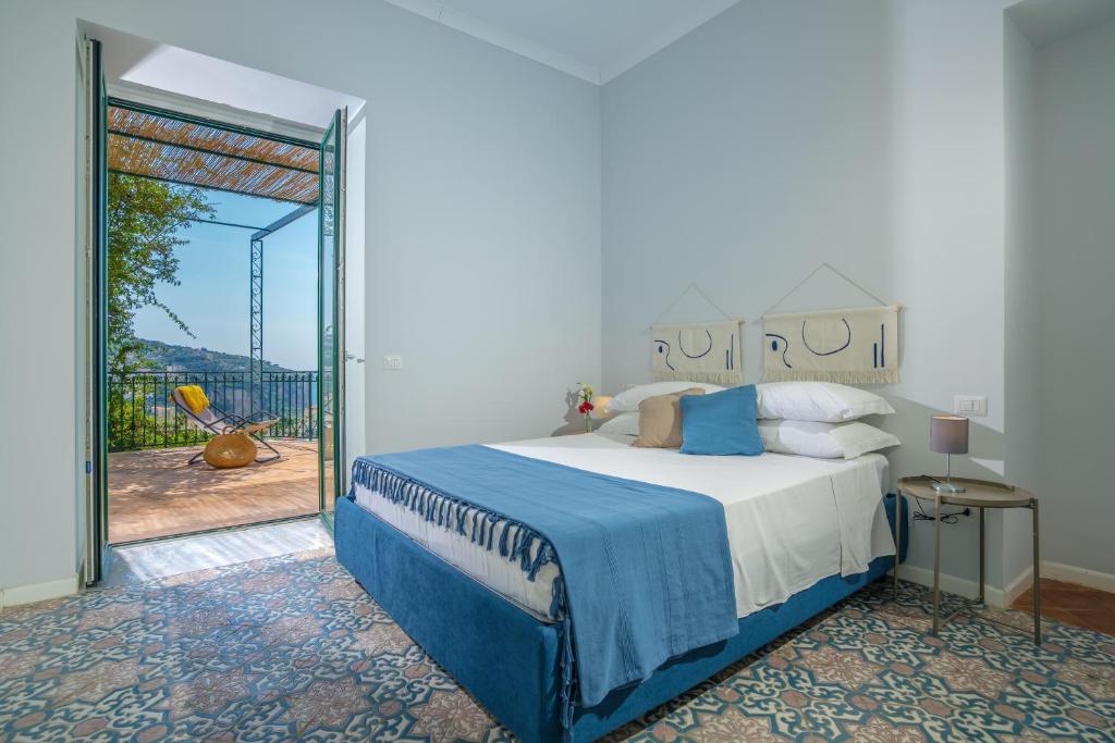 Schlafzimmer mit einem Bett und einer Glasschiebetür in der Unterkunft Villa Chiara in Vico Equense