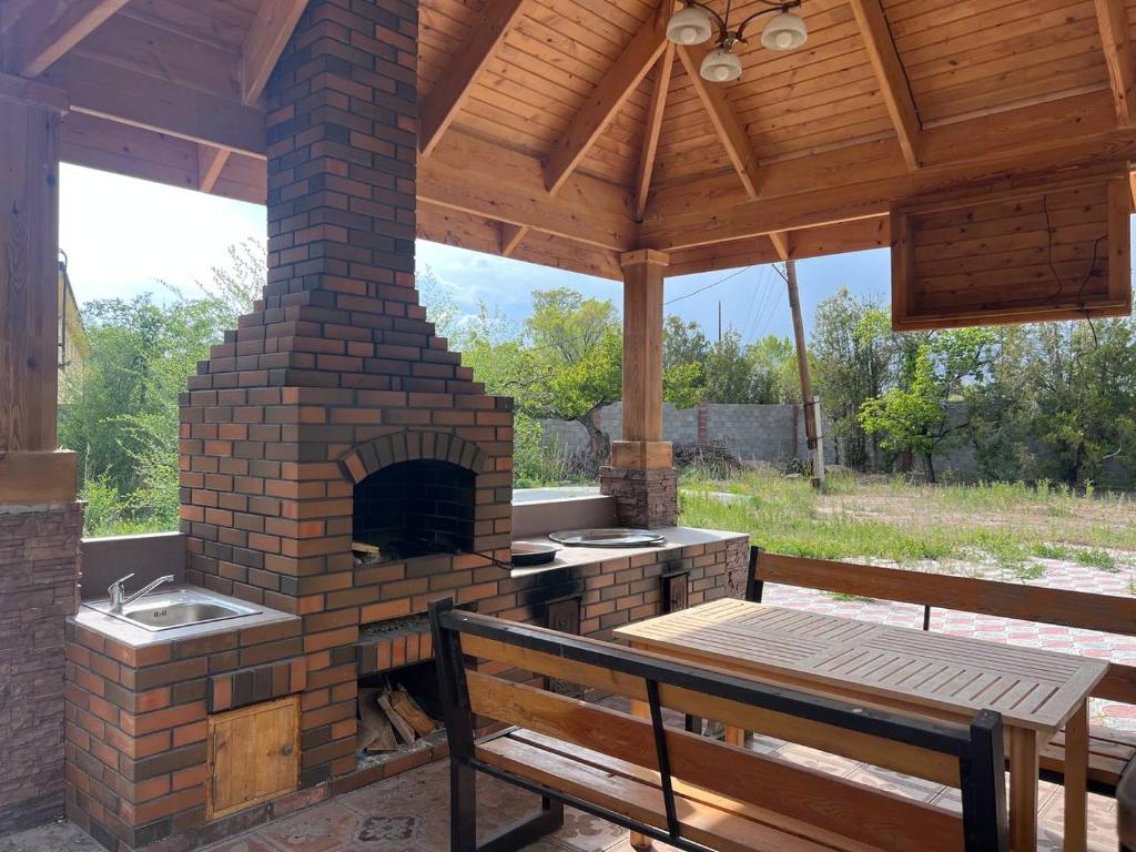 un patio con un horno al aire libre y un banco en Lakeside Villa Issyk Kul, en Cholpon-Ata