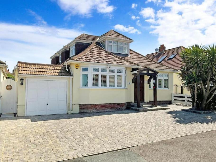 a yellow house with a white garage at Botany Bay view Seaside Home in Broadstairs