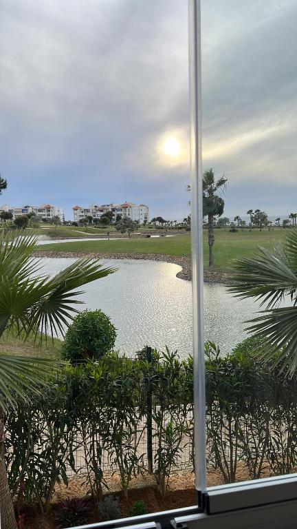 uma vista para uma massa de água a partir de uma janela em Marina golf em Asilah