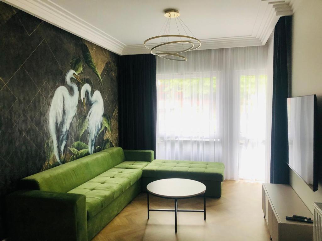 - un salon avec un canapé vert et une table dans l'établissement Solankowe Zacisze De Lux Inowrocław, à Inowrocław