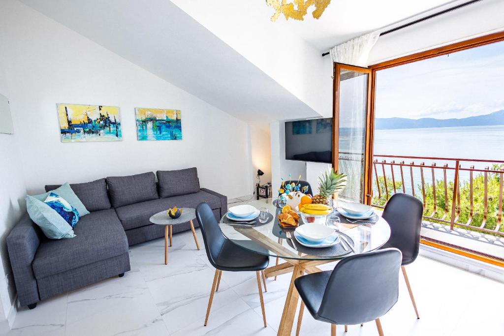 uma sala de estar com um sofá e uma mesa com cadeiras em Lux Gradac em Gradac