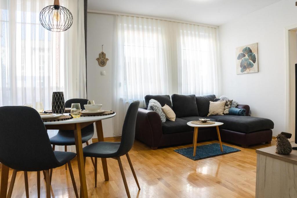 a living room with a couch and a table at Flexible SelfCheckIns 52 - Zagreb - Parking - Loggia in Zagreb