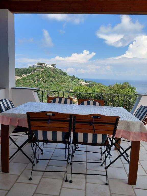 a table on a balcony with a view of the ocean at Villetta Panoramica in Ischia