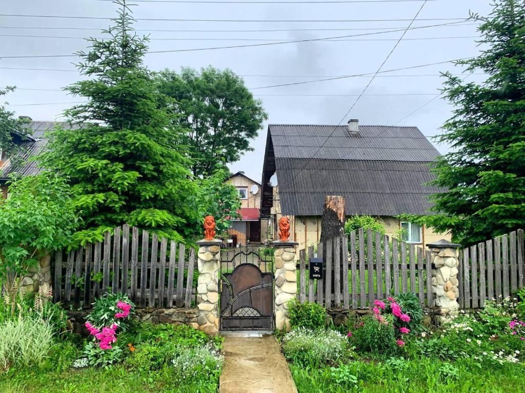 uma cerca com um portão em frente a uma casa em Ny to Abzatc em Slavske