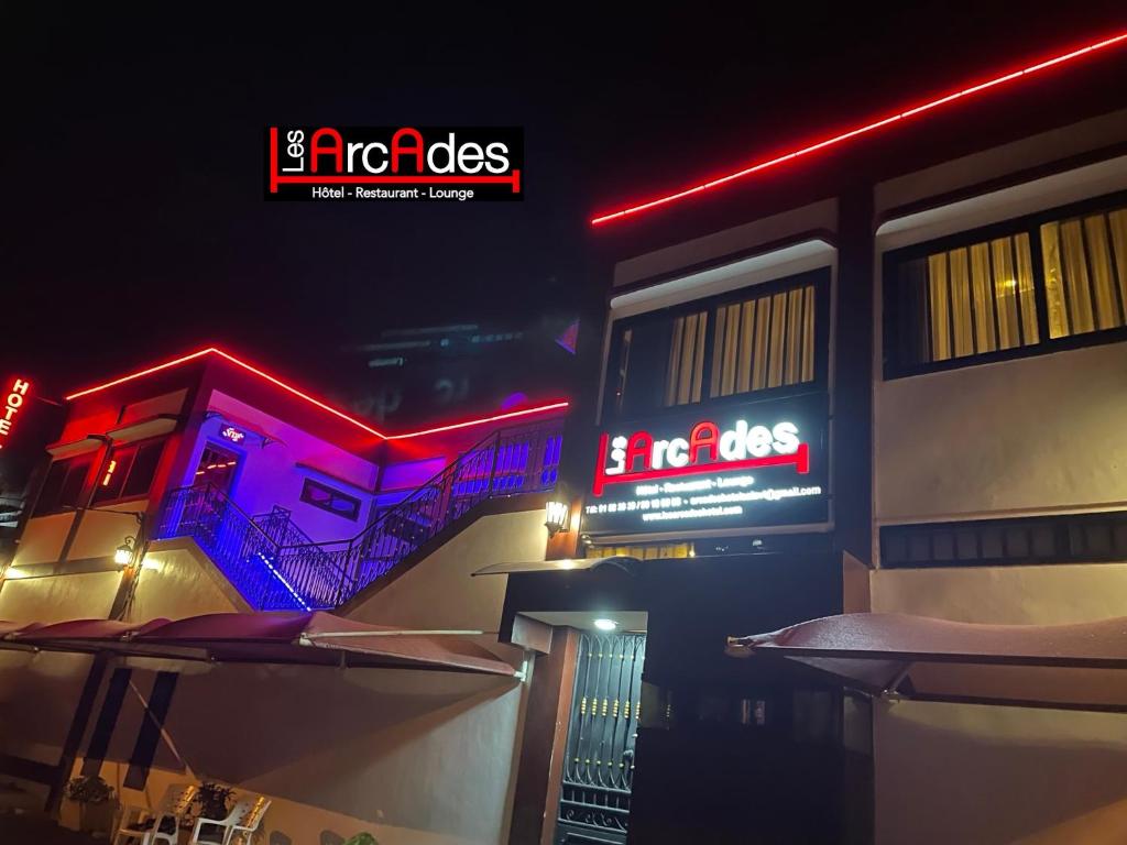 a building with a neon sign on the side of it at HOTEL LES ARCADES in Cotonou