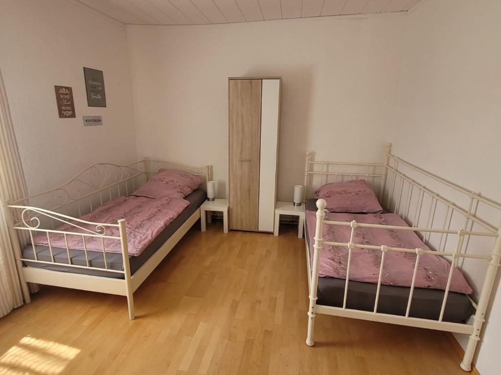 2 Betten in einem Zimmer mit Holzböden in der Unterkunft Ferienwohnung - Stein - in Rollshausen
