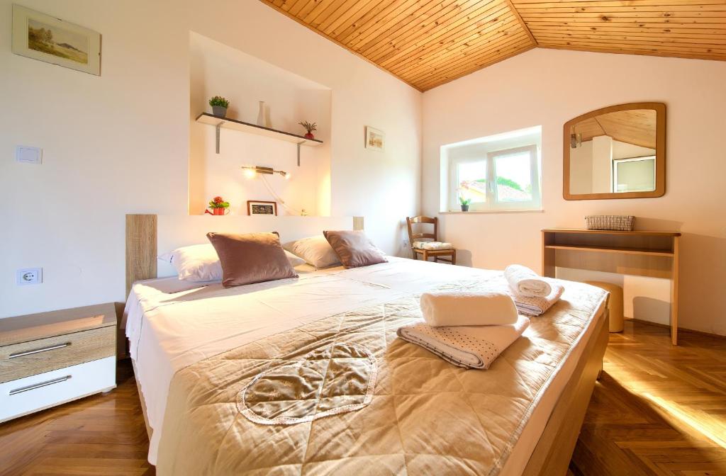 ein Schlafzimmer mit einem großen Bett mit einem Spiegel und einem Schreibtisch in der Unterkunft Apartment Lipovac in Malinska