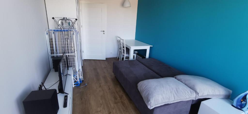 Habitación azul con cama y escritorio. en Nowy 1 z 2 pokoi w mieszkaniu w Ursusie, en Varsovia
