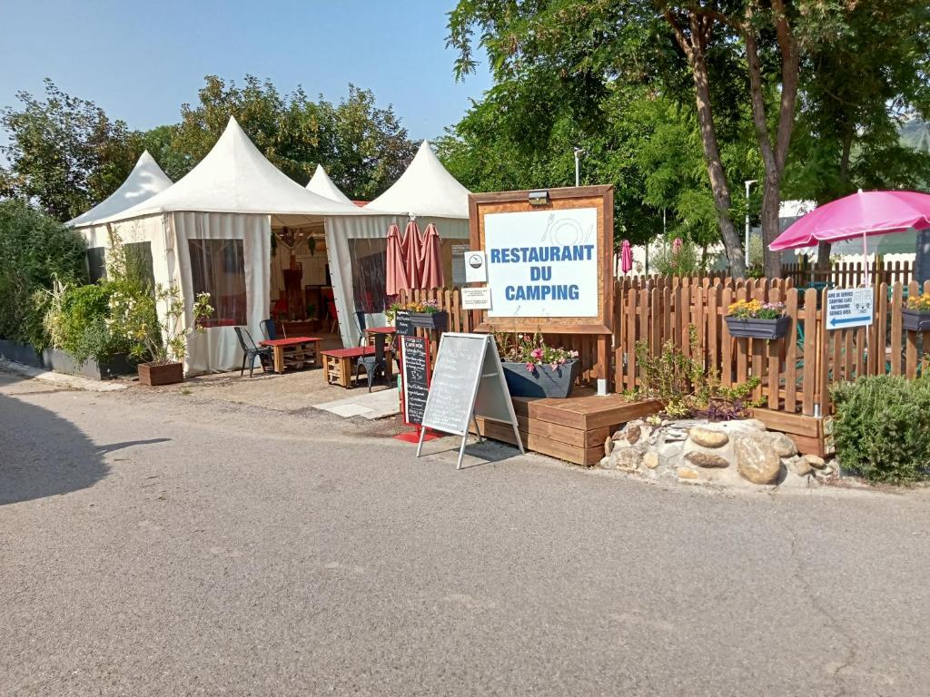 an outdoor market with a tent and a sign at mobil-home du lac de Foix in Foix