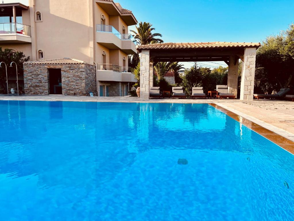 a large blue swimming pool next to a building at Lili Hotel in Amoudara Herakliou