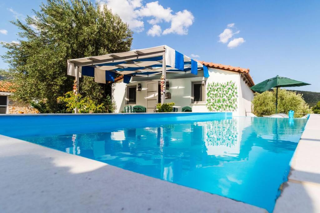 a villa with a swimming pool and a house at Little Artemis Cozy Cottage in Argos