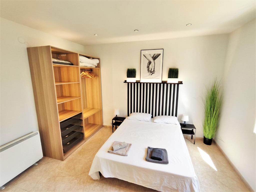 a bedroom with a white bed and a closet at Luminoso Apartamento enfrente del AVE in Puertollano