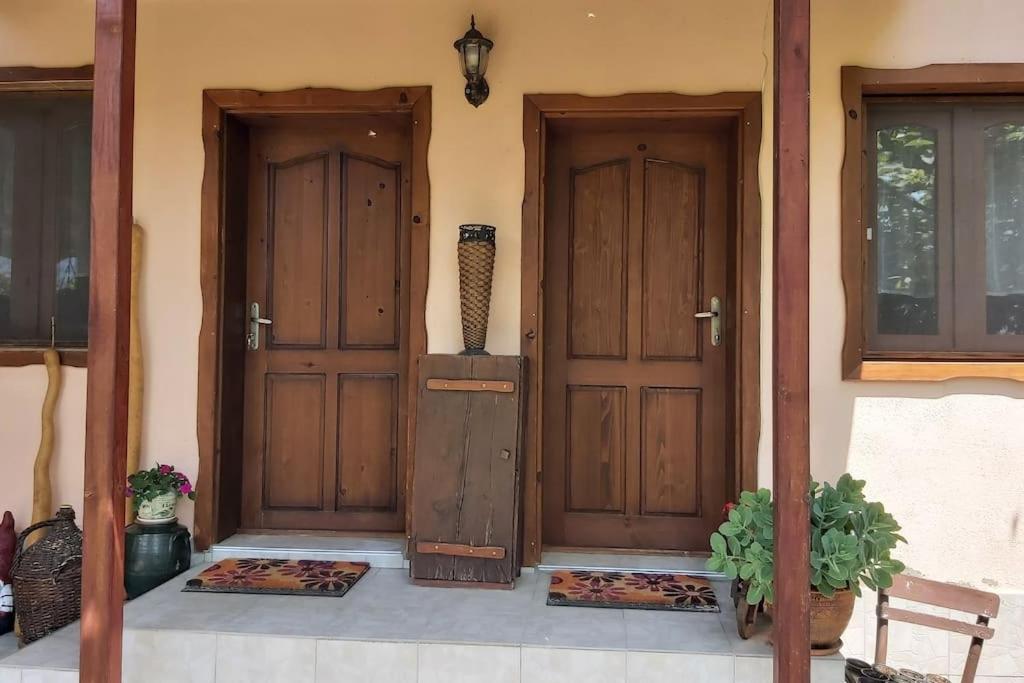 zwei Holztüren eines Hauses mit Pflanzen in der Unterkunft Къща за гости в селска местност in Petrich