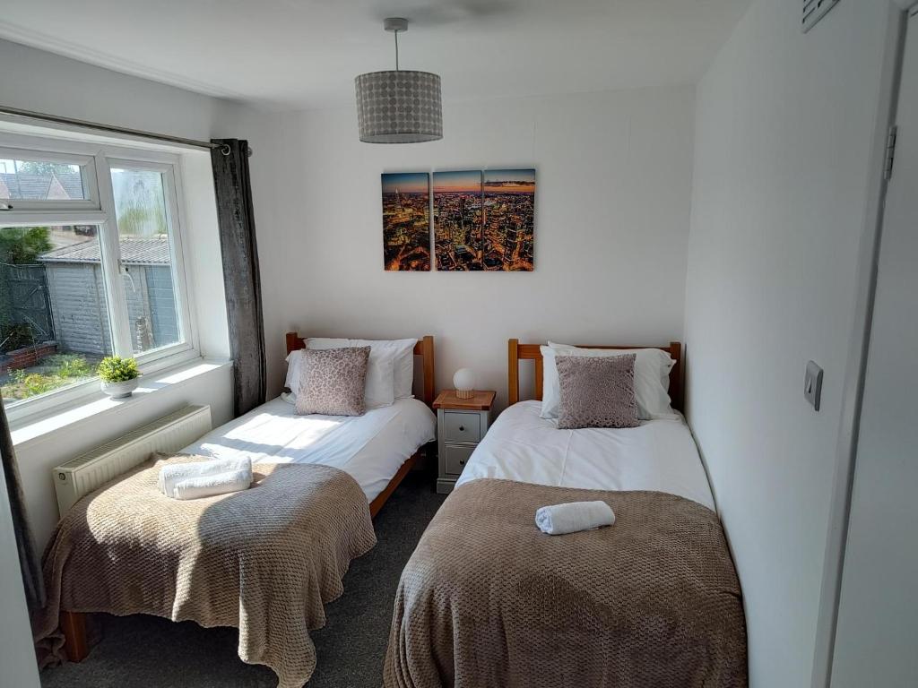 sypialnia z 2 łóżkami i oknem w obiekcie Jarvis Drive 3 Bed contractor house In melton Mowbray w mieście Melton Mowbray