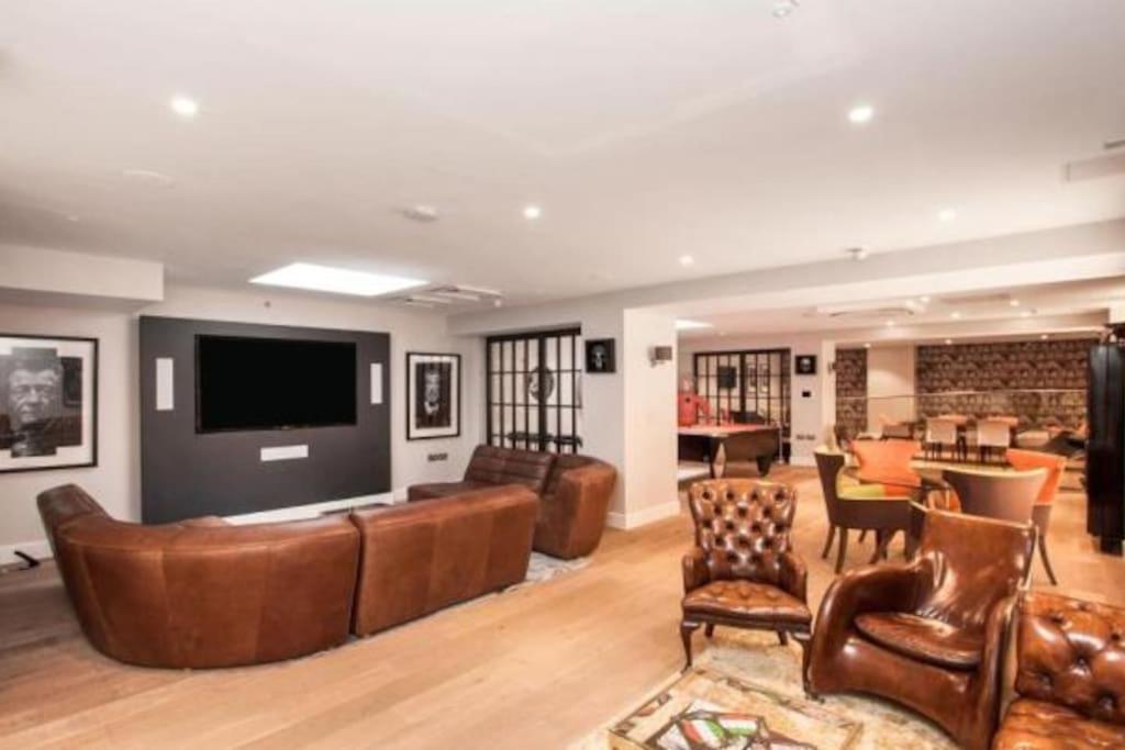 uma sala de estar com mobiliário de couro e uma televisão de ecrã plano em New Flat (12 mins Central London/Gatwick Airport) em Croydon