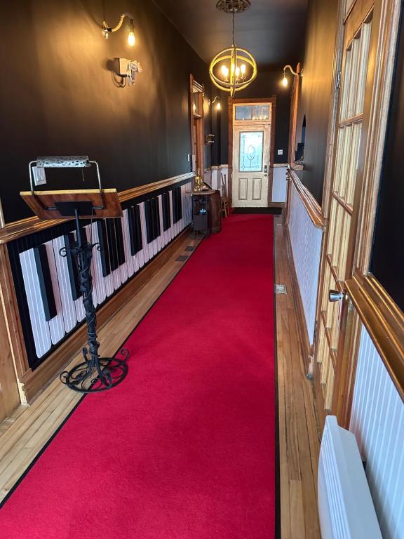 un tappeto rosso in un corridoio con tappeto rosso di AUBERGE et BISTRO NAMASTÉ a Lachute