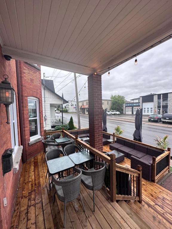 a patio with tables and chairs on a wooden deck at AUBERGE et BISTRO NAMASTÉ in Lachute