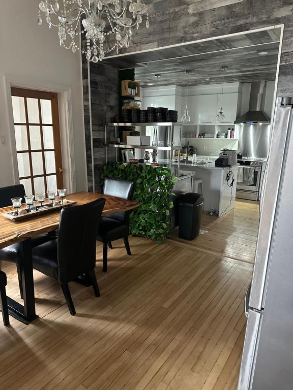 a kitchen and dining room with a wooden table and chairs at AUBERGE et BISTRO NAMASTÉ in Lachute