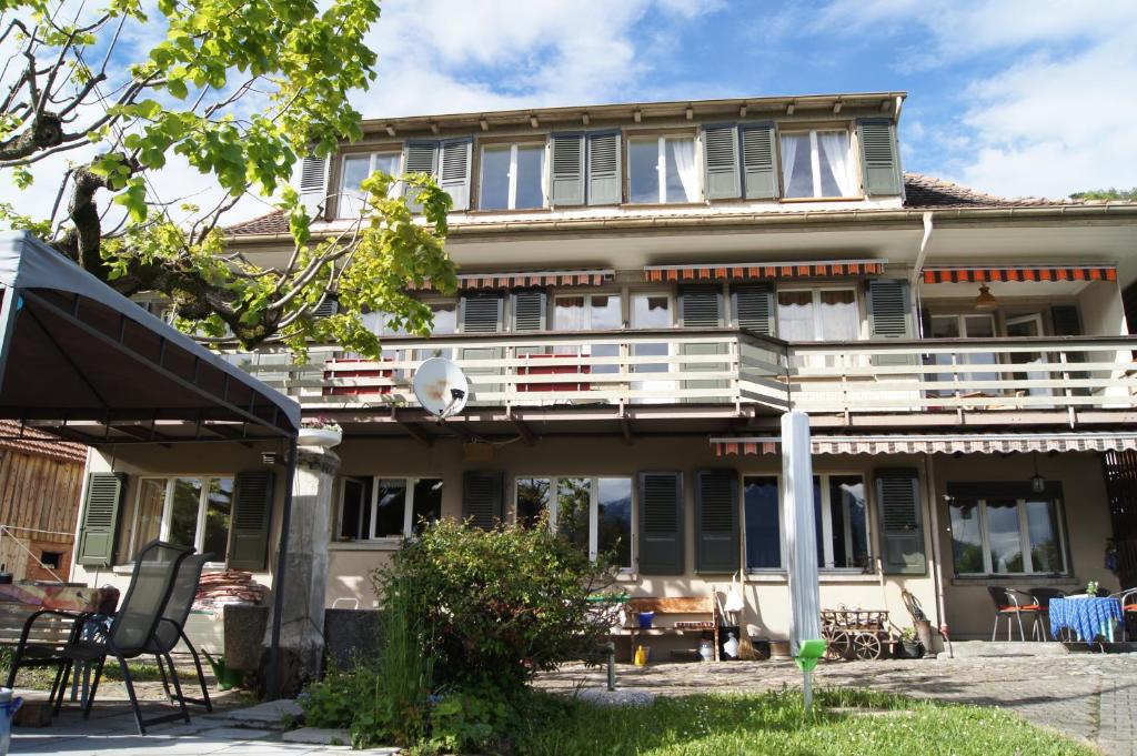 ein älteres Haus mit einem Balkon und einer Terrasse in der Unterkunft B&B Schönörtli in Gunten