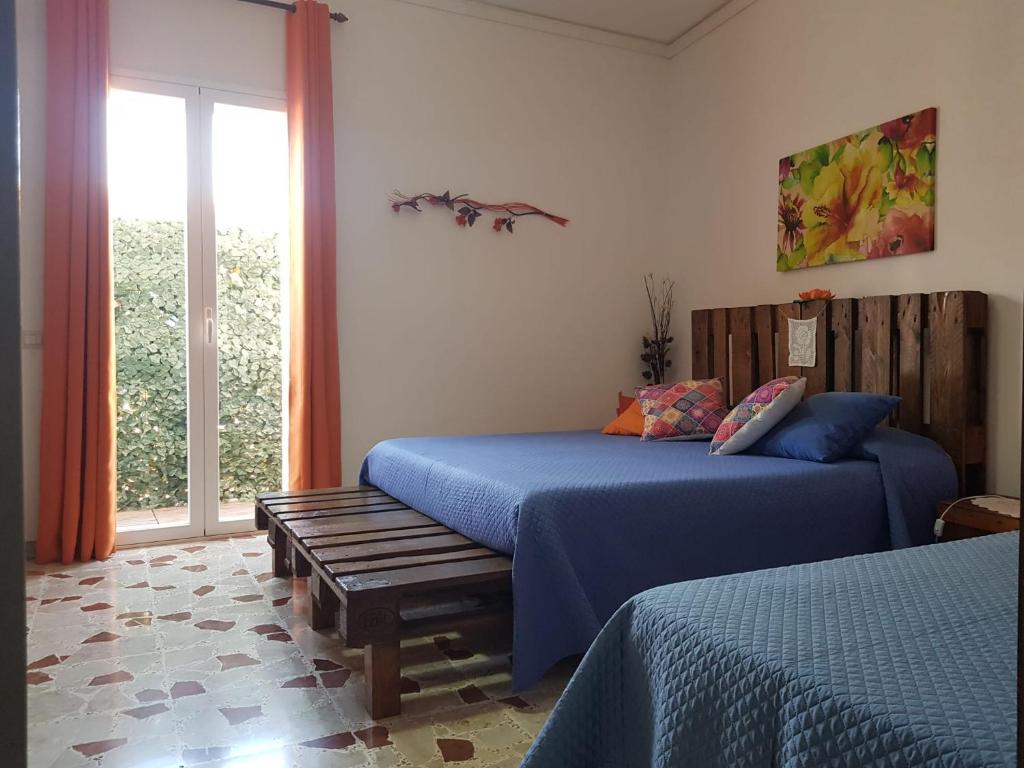 a bedroom with two beds and a window at B&B CARRUBBELLE in Ragusa