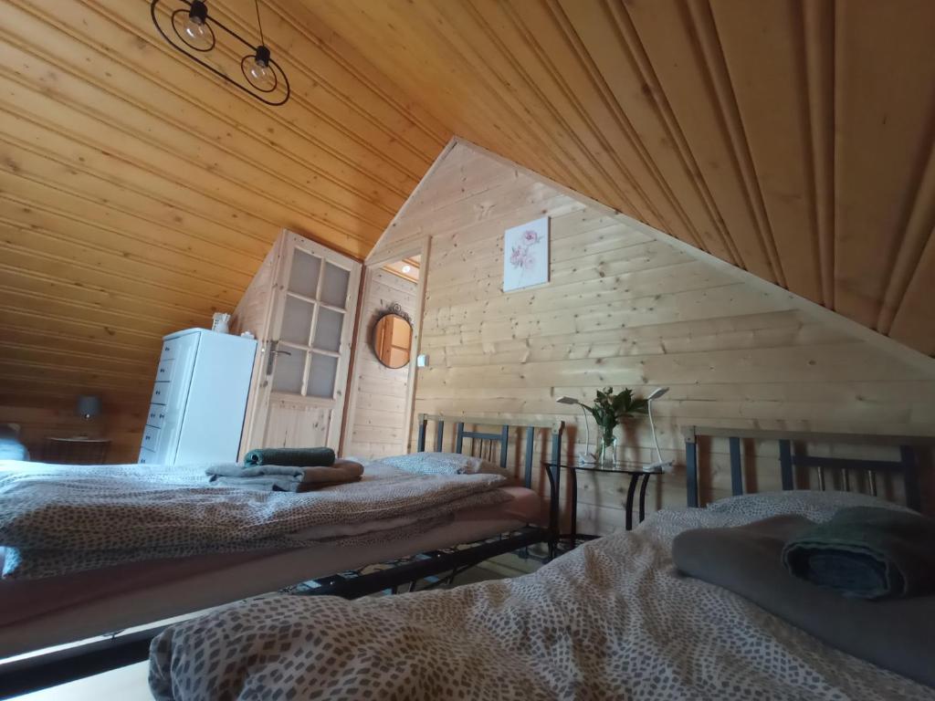 Habitación con 2 camas en una cabaña de madera en U Krysi, en Kojszówka