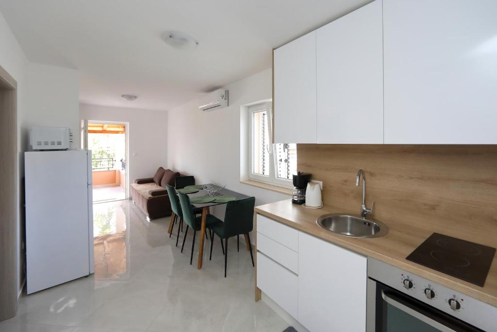 una cucina con un lavello e un tavolo con sedie di Alfonso a Bibinje (Bibigne)