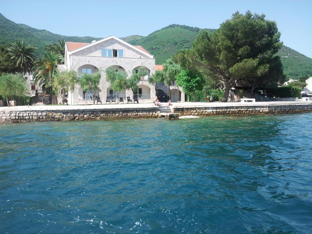 a house on the shore of a body of water at Apartments Villa Danilovic in Herceg-Novi