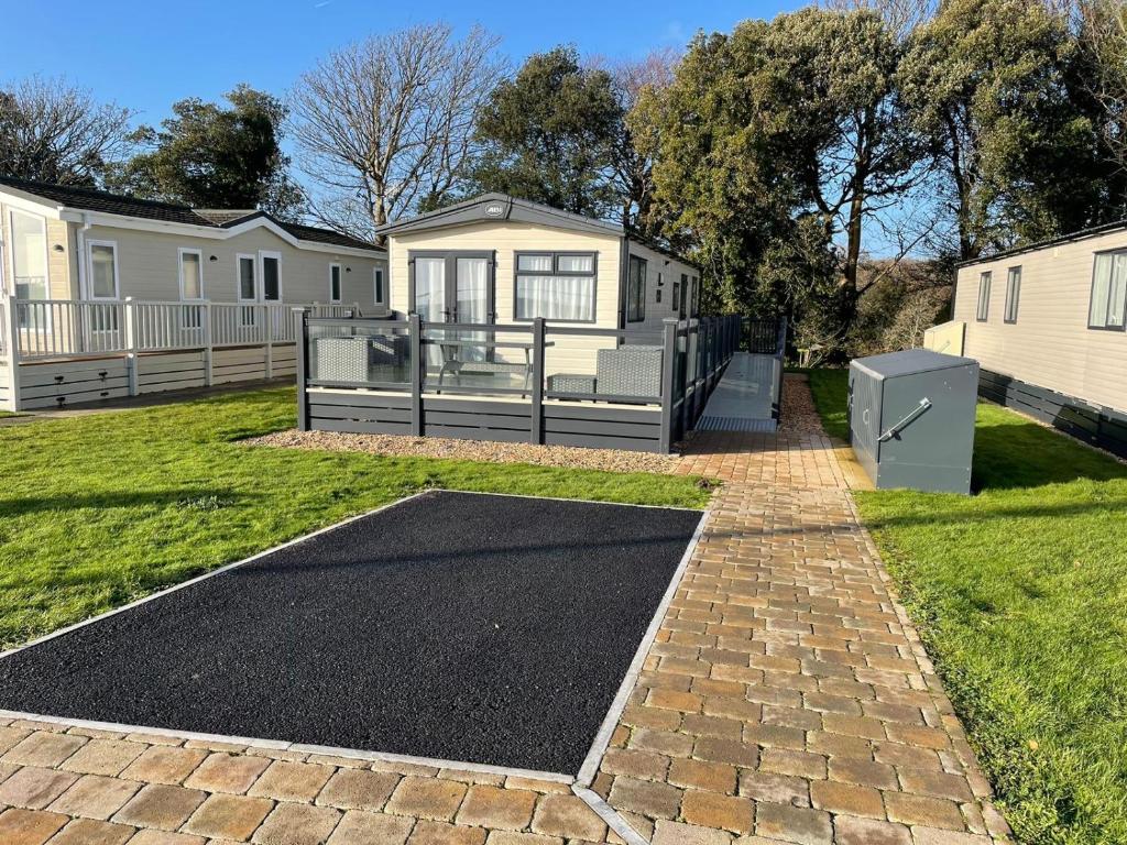 una entrada que conduce a una casa con un edificio en Emma's Pad at Hoburne Naish - New Forest - Wheel chair Accessible with wetroom and ramp en Highcliffe