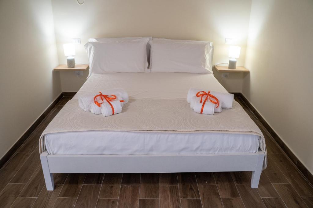 ein weißes Bett mit zwei weißen Kissen darauf in der Unterkunft Casa Badia in Santa Venerina