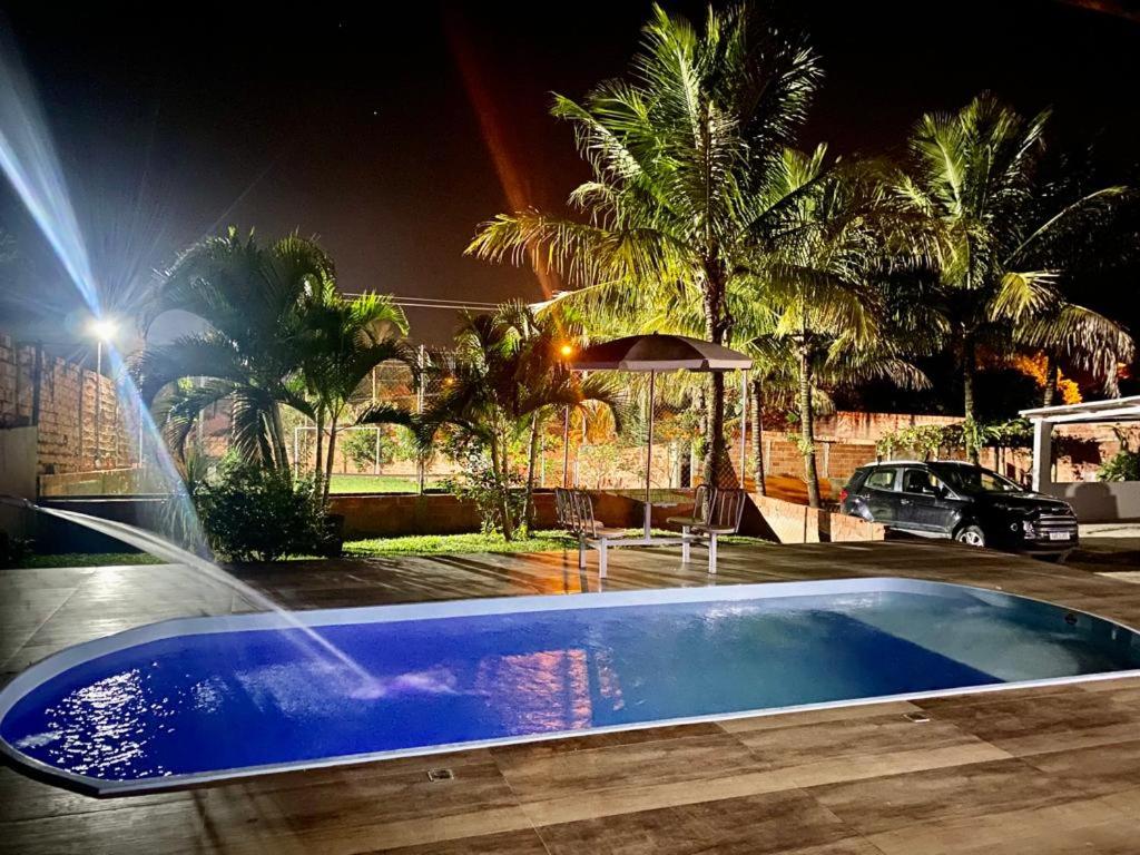 a house with a swimming pool at night at Chacara Oliva in Piracicaba