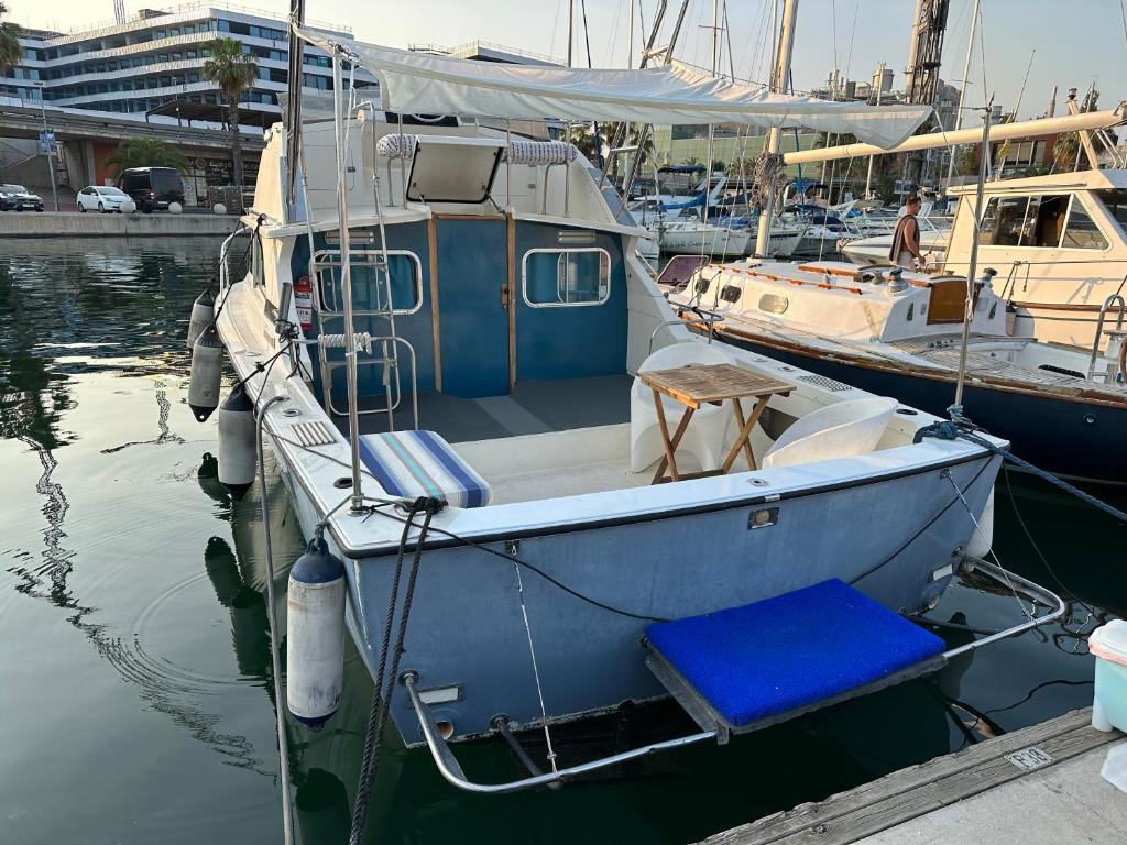 巴塞隆納的住宿－!!Boat with AC in Port Forum 2 Bikes Included!!，停靠在水面码头的蓝色小船