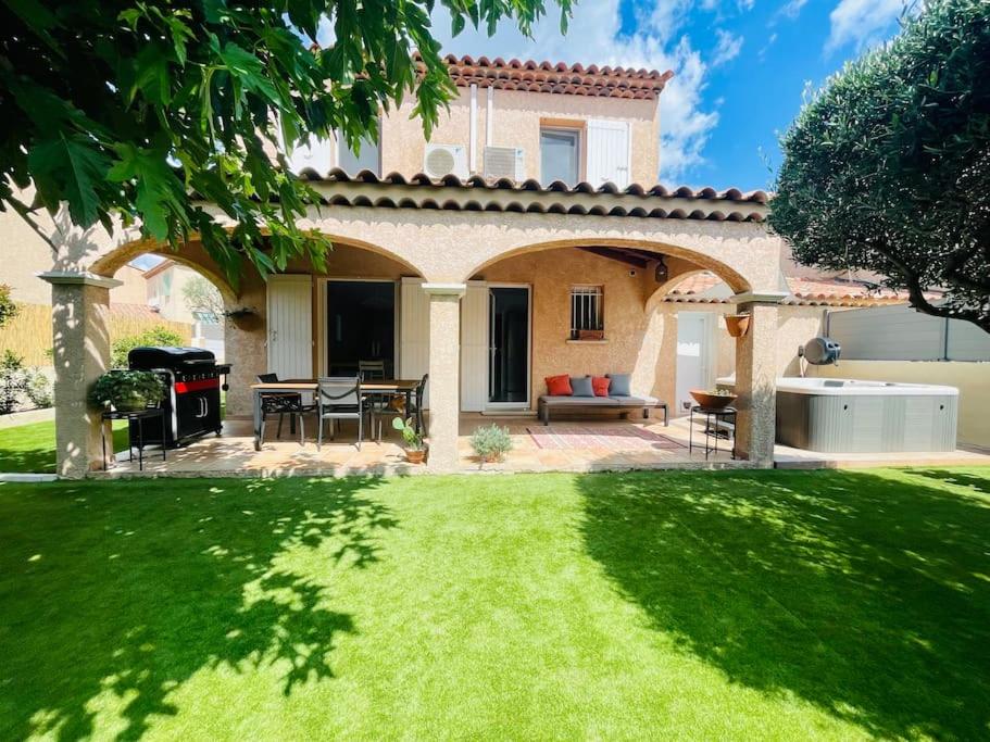 a house with an outdoor patio with a lawn at Maison familiale avec Jacuzzi in Plan-de-Cuques