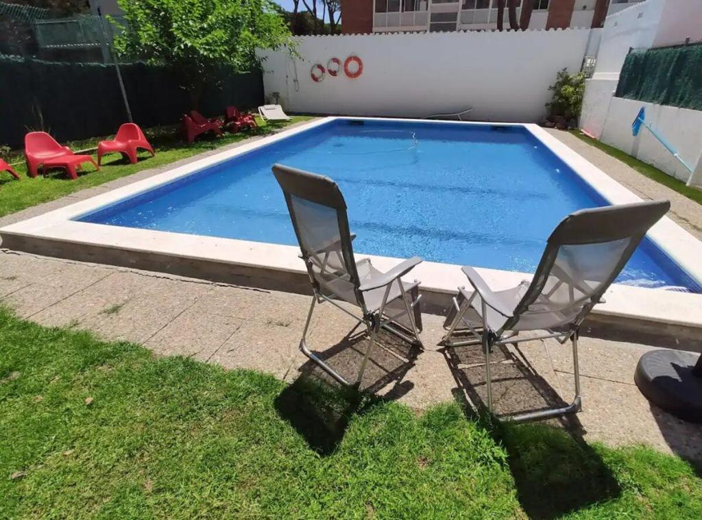 two chairs sitting next to a swimming pool at Chelor in Castelldefels