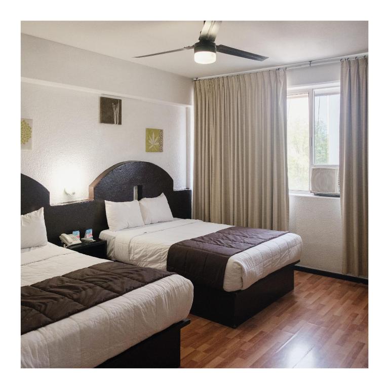 Postel nebo postele na pokoji v ubytování Hi Hotel Impala Queretaro