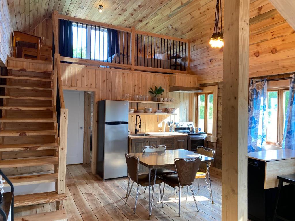 a kitchen and dining room with a table in a cabin at Le Hangar in La Malbaie