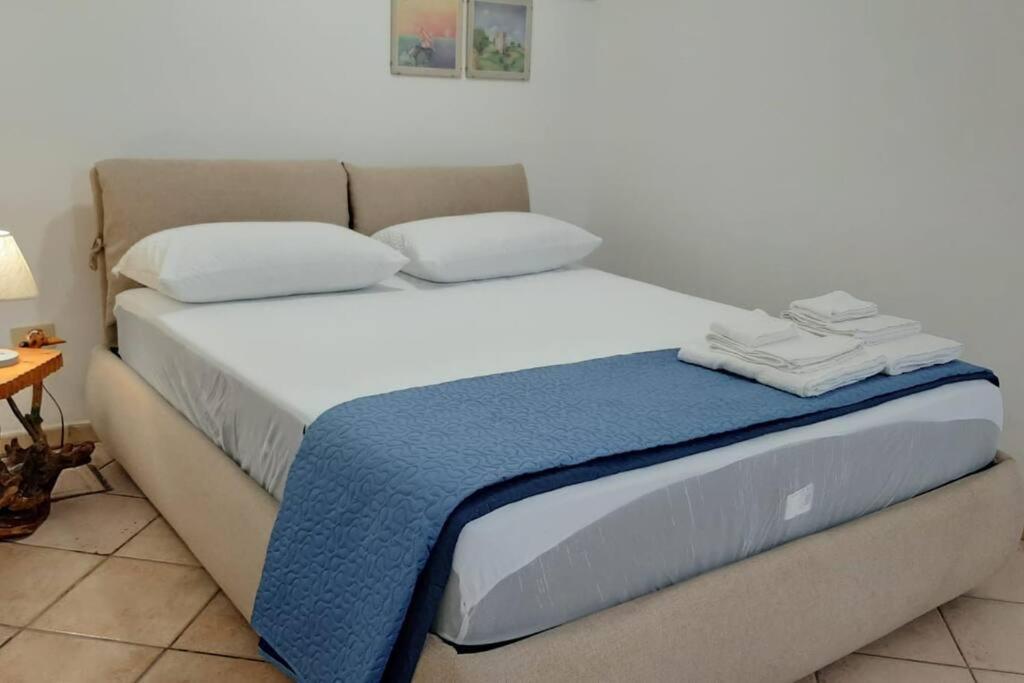 Una cama con una manta azul encima. en Casa di GiAde en Anguillara Sabazia