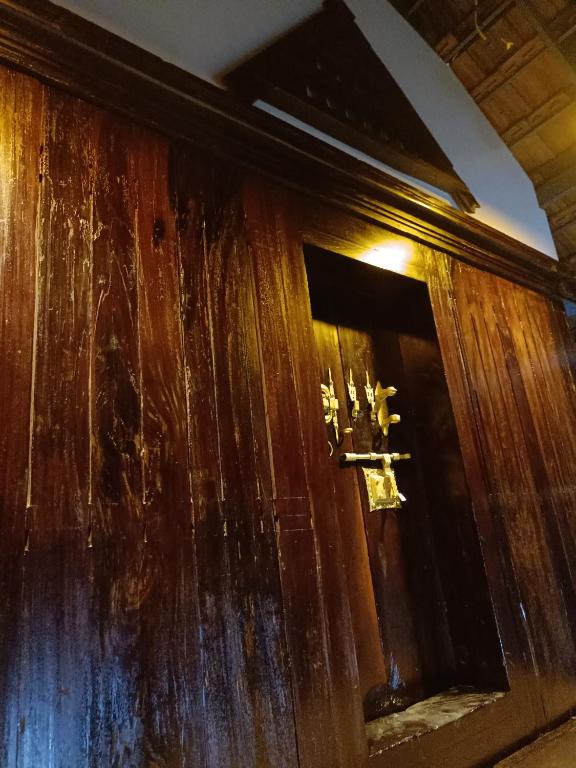 a wooden door with a cross on it at Anandam Woods - A Heritage single Room for couple-small family in Vaikom