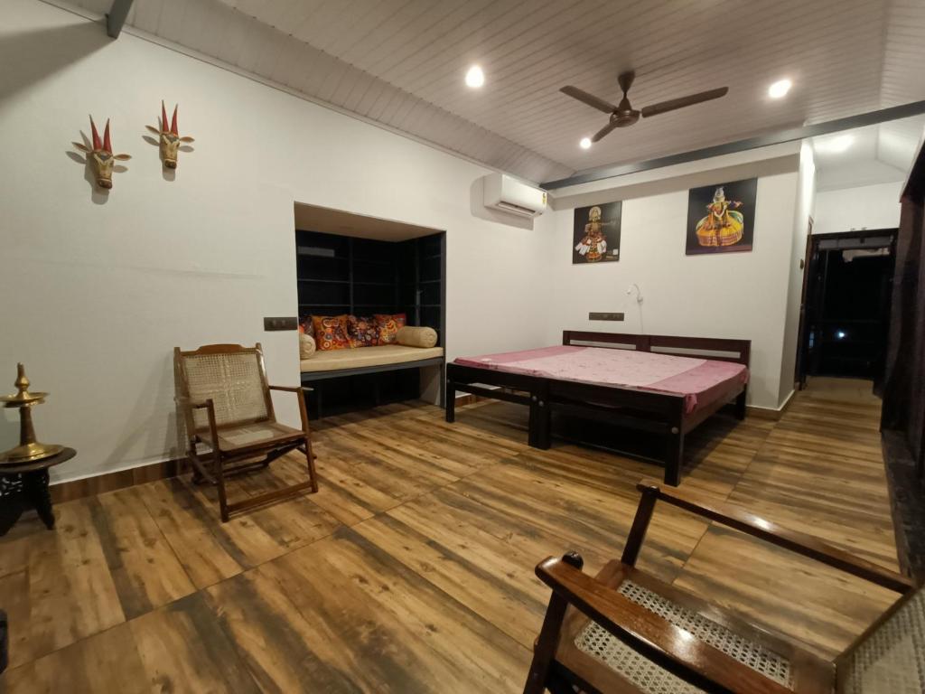 a living room with a bed and a couch at Anandam Woods - A Heritage single Room for couple-small family in Vaikom