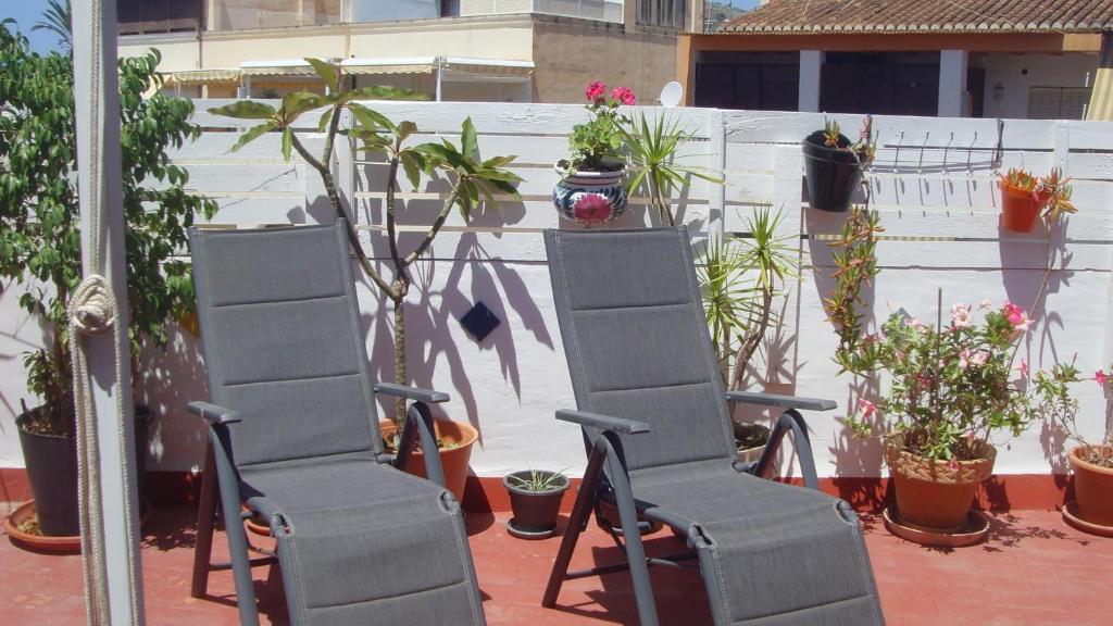 two chairs in front of a fence with potted plants at Centrico Atico Apt Sleeps 4 with Patio in Almuñécar