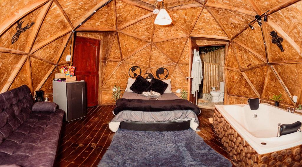 a bedroom with a bed and a tub in a yurt at Glamping Sunset Hill Salamina-Caldas in Aranzazu