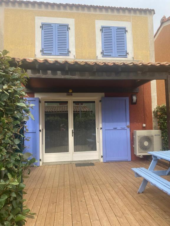 une porte d'entrée d'une maison avec des portes bleues dans l'établissement Maison cosy au bord de la mer, au Barcarès