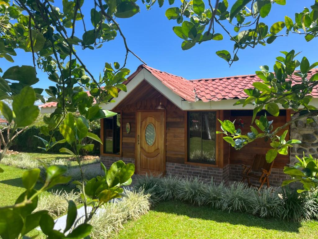 a cabin with a wooden door in a yard at Pitangus Lodge in Chachagua