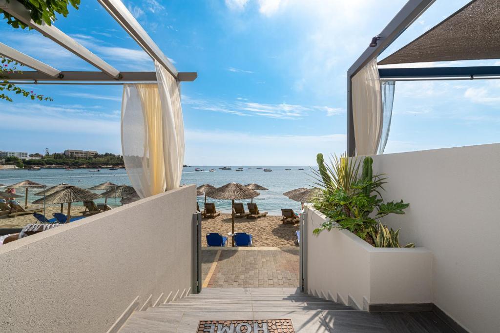 - une vue sur la plage depuis le balcon d'une maison de plage dans l'établissement Buganvilla-Sea front villas, à Agia Pelagia