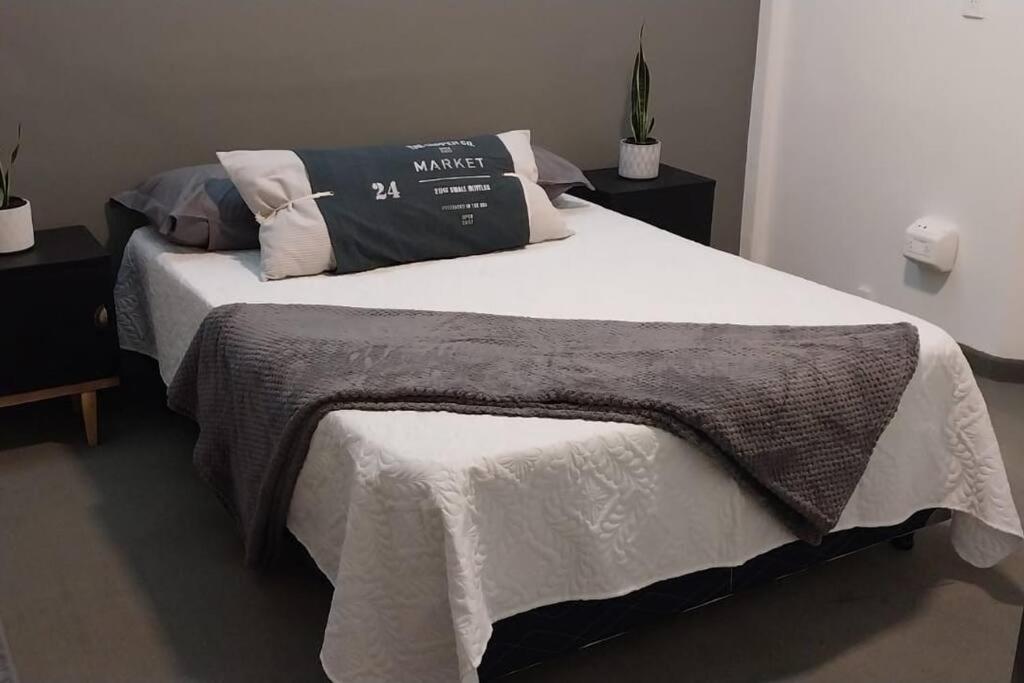 uma cama com um cobertor e almofadas em Moderno y acogedor departamento céntrico em Posadas