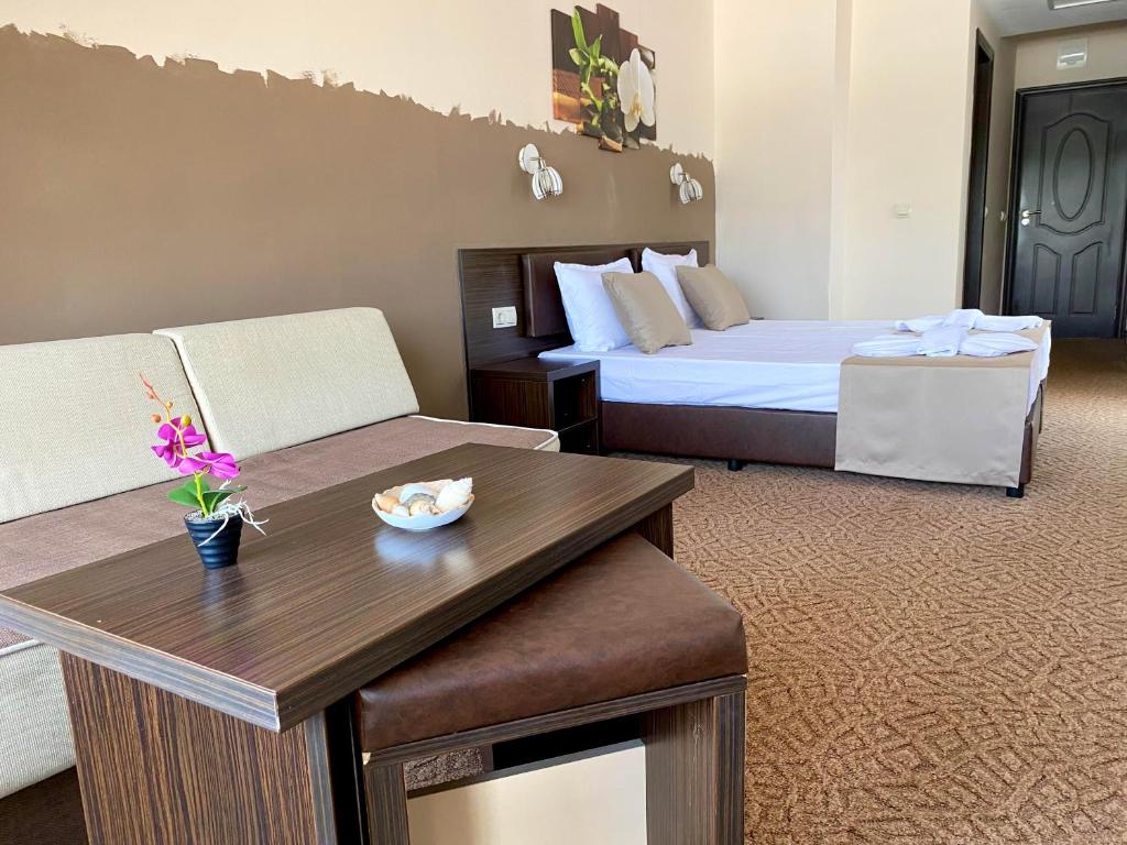 une chambre d'hôtel avec un lit et un canapé dans l'établissement Family Hotel Teos, à Kiten