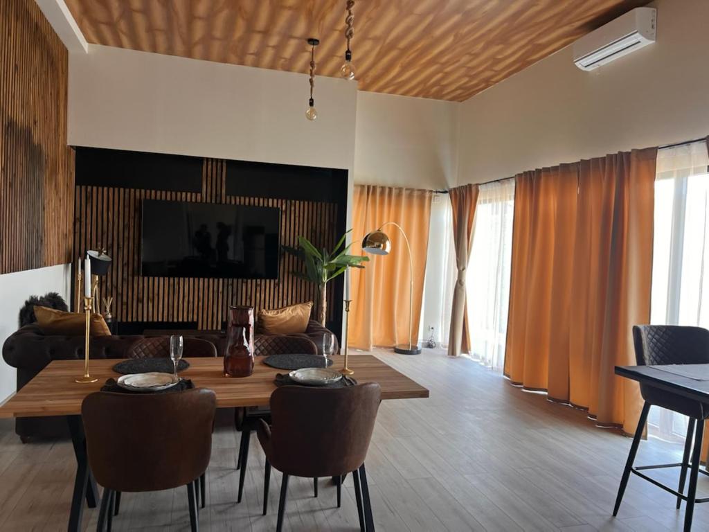 ein Wohnzimmer mit einem Tisch, Stühlen und einem Sofa in der Unterkunft DMM SUITS in Boé