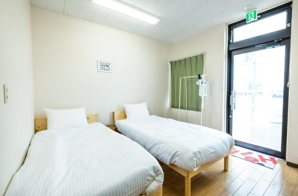 two beds sitting next to each other in a room at Ezo Fujiya Niseko House - Vacation STAY 14768 in Kutchan