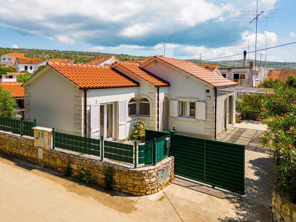a house with a green fence in front of it at Anda - Kuća za odmor in Milna
