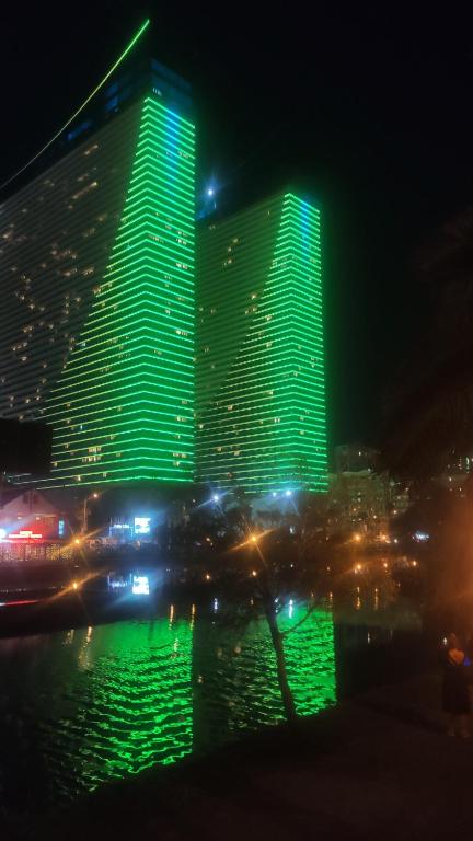 um grande edifício com luzes verdes à noite em Orbi-city Batumi Apartments em Batumi